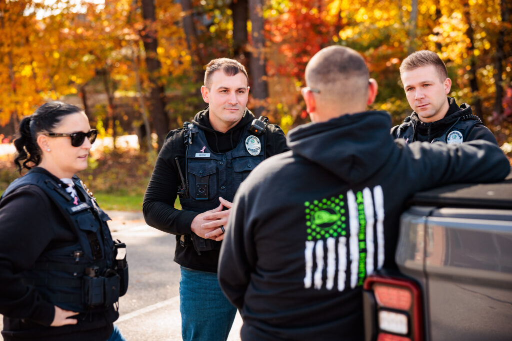 Three police members talk to a citizen.