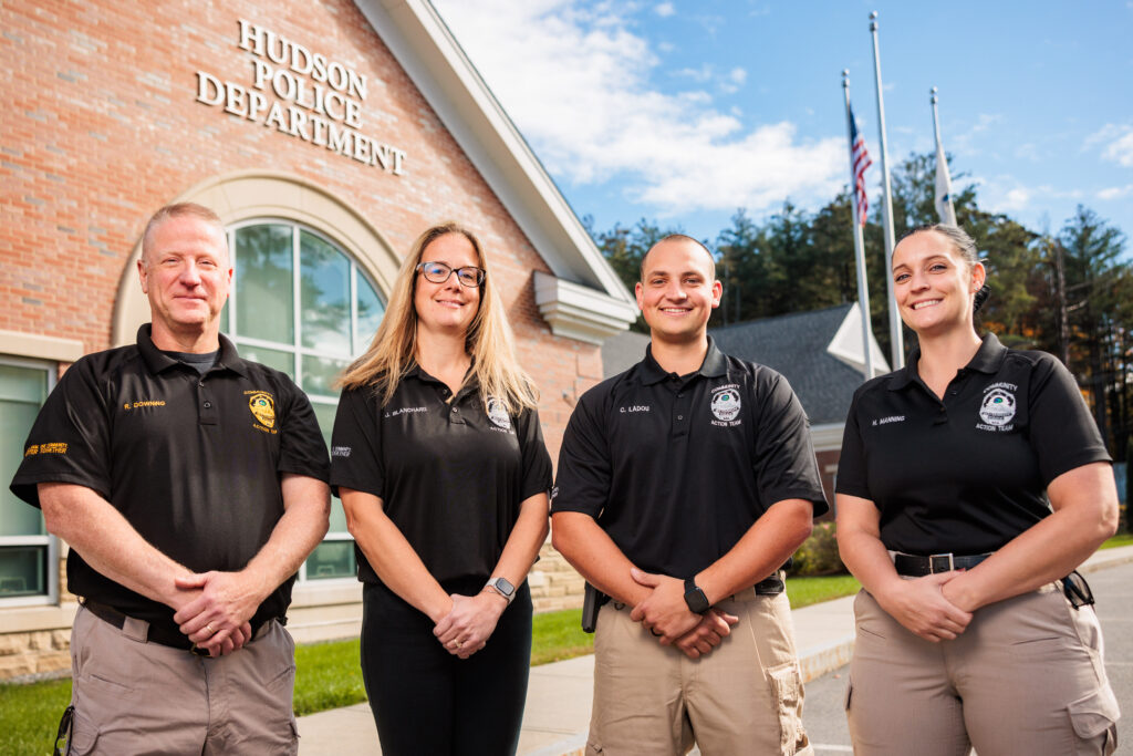The four members of the community action team stand in front of the police headquarters.