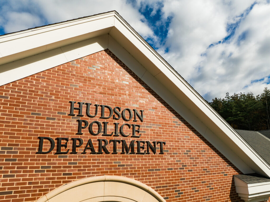 Closeup of the Hudson Police Department sign on the exterior of the headquarters